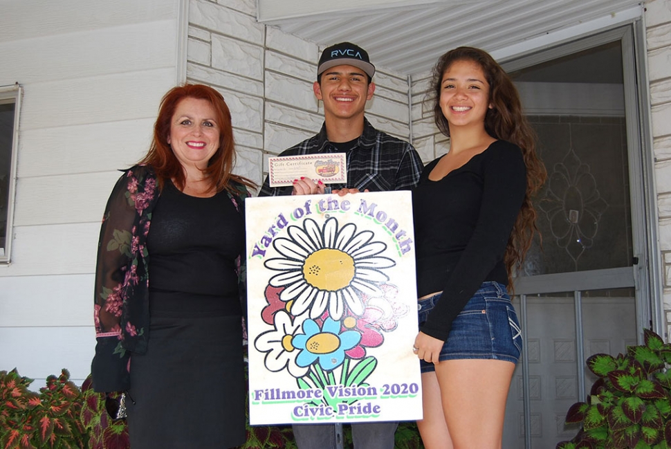 Theresa Robledo, assisting with the presentation of Fillmore Vision 2020 Civic Pride’s Yard of the Month for June awarded to Mr. and Mrs. Gutierrez. However Mr. and Mrs. Gutierrez were a little camera shy so their children Enrique and Mariela accepted the award on their behalf. Their yard has lushes greens, beautiful manicured trees, and vibrant colored roses. Please feel free to drive by their yard located at  El Dorado Space #26. A big Thank you to Otto And Sons!